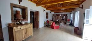a living room with a table and a red chair at Casa da Bisa - Santa Maria - Açores in Santa Bárbara
