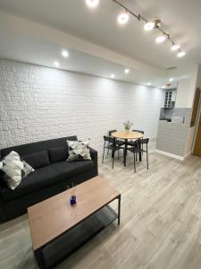 a living room with a couch and a table at The Works - Private one bedroom apartment in Manchester