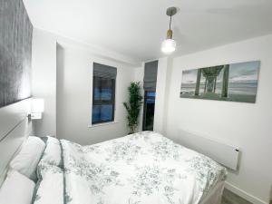 een witte slaapkamer met een bed en een bank bij The Works - Private one bedroom apartment in Manchester