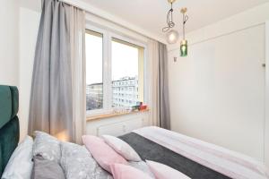 - une chambre avec un lit et une fenêtre dans l'établissement SmileApartment Świętojańska, à Gdynia