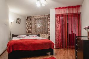 ブラショヴにあるSMB Holiday Apartmentのベッドルーム1室(赤いベッド1台、赤いカーテン付)