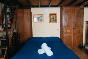 una camera con letto con lenzuola blu e scala di Casa Vincenzina ad Atrani
