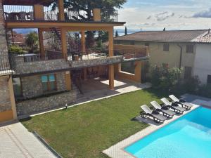 a yard with lounge chairs and a swimming pool at B&B Al Vec Licinsi' in Moniga