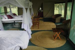 una camera da letto con tenda, letto e tavolo di Osero Serengeti Luxury Tented Camp a Banagi