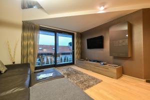 a living room with a couch and a large window at Villapark Luxury Apartman Balatonfüred in Balatonfüred