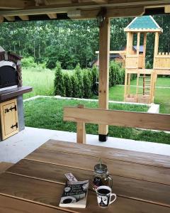 a wooden table with a cup of coffee on a patio at Drinska Idila apartmani in Vrhpolje