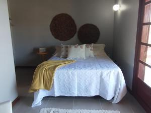 a bedroom with a bed with a white comforter at Casa de veraneio Lar doce mar in Capão da Canoa