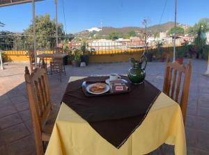 una mesa con un plato de comida y un jarrón en ella en Posada Regional, en Oaxaca City
