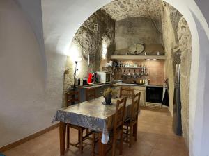 eine Küche mit einem Tisch und Stühlen sowie eine Küche mit einer Theke in der Unterkunft Luberon maison de village entière 2 à 6 personnes in Cabrières-dʼAigues