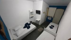 Kleines weißes Zimmer mit 2 Betten. in der Unterkunft Pousada da Ponte in Praia de Araçatiba