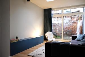 ein Wohnzimmer mit einem Sofa und einem Fenster in der Unterkunft Margareta Stay in Mechelen