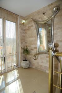 ein Bad mit einer Dusche und einem großen Spiegel in der Unterkunft "HOLIDAY" apartments & rooms in Ulcinj