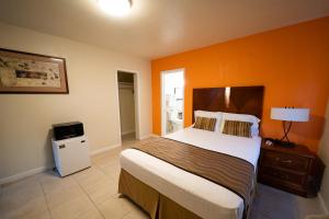 a bedroom with a large bed with an orange wall at Stay Inn Suite in Stockton +18 photos