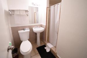 a bathroom with a toilet and a sink and a mirror at Stay Inn Suite in Stockton