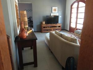 a living room with a couch and a table at Casa de veraneio Lar doce mar in Capão da Canoa