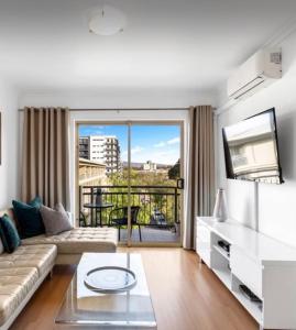 a living room with a couch and a large window at Forest of Dreams in Adelaide