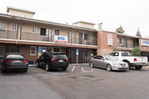 a parking lot with cars parked in front of a hotel at Stay Inn Suite in Stockton