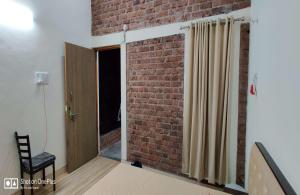 a room with a brick wall and a door at GREEN VISION RESORT in Murbād
