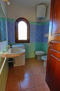 La salle de bains est pourvue d'un lavabo, de toilettes et d'une fenêtre. dans l'établissement Residence Stella Marina, à San Teodoro