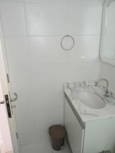 a white bathroom with a sink and a mirror at Villa Monrealle Praia Itaguá in Ubatuba