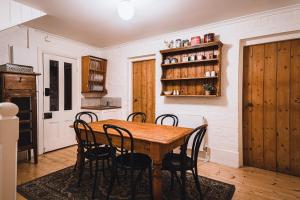 a dining room with a wooden table and chairs at Campbell House in Castlemaine