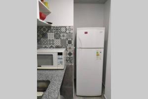 y cocina con nevera y microondas. en Departamentos Calasanz PB 4 en Mar del Plata