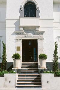 a white building with stairs leading up to a door at The Convent Hotel in Auckland
