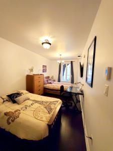 sypialnia z 2 łóżkami i biurkiem w obiekcie Maison Montplaisir w Montrealu