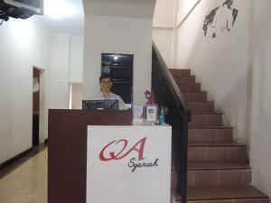 a man standing at a reception desk in a building at Omah Ambarukmo in Yogyakarta