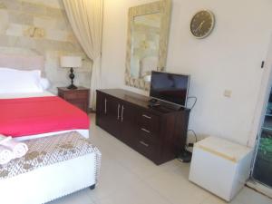 Dormitorio con cama y tocador con TV en Oase Van Java, en Salatiga