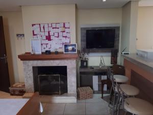 a living room with a fireplace and a television at Centro Studio in Uruguaiana