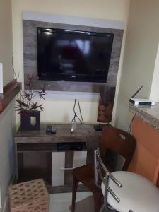sala de estar con TV y mesa con silla en Centro Studio en Uruguaiana