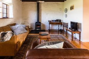 sala de estar con sofá y chimenea en Daisy Bank Cottages, en Richmond