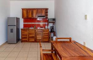 a kitchen with wooden cabinets and a wooden table at Hotel Casa Pridda in Puerto Escondido