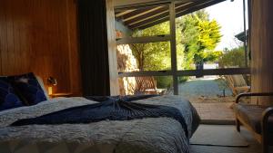 sypialnia z łóżkiem i dużym oknem w obiekcie Peak Sport Chalet w mieście Wanaka