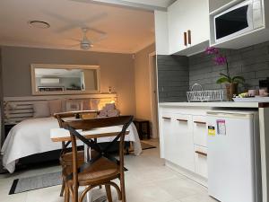 uma cozinha com uma cama, uma mesa e cadeiras em Paperbark Bed & Breakfast em Brisbane