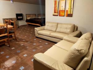 a living room with a couch and a table at Cabaña La Victoriana in Creel