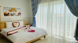 a bedroom with a bed with a heart pillow on it at Sao Mai hotel in Con Dao