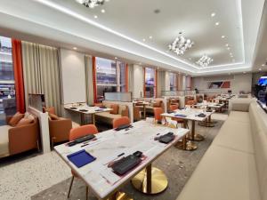 a restaurant with tables and chairs and windows at Citic Ningbo International Hotel in Ningbo