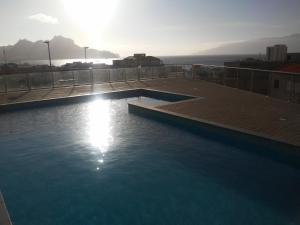 uma piscina no telhado de um edifício com o pôr do sol em Ocean View Stay em Mindelo
