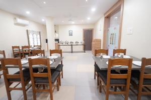 a dining room with a table and wooden chairs at Hotel Prime Inn in Warangal