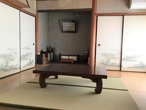 - une table basse dans une chambre dotée de grandes fenêtres dans l'établissement 富乃亭, à Maniwa