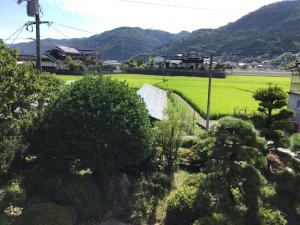 a view of a garden with a field and mountains at 富乃亭 in Maniwa
