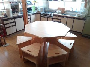 Il comprend une cuisine avec une table et des chaises en bois. dans l'établissement 富乃亭, à Maniwa