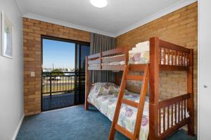 a bedroom with two bunk beds and a balcony at Illawong Apartments in Mooloolaba