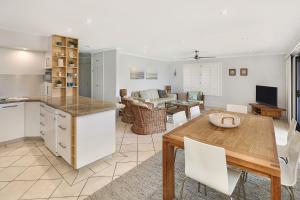 a kitchen and living room with a table and a dining room at Illawong Apartments in Mooloolaba