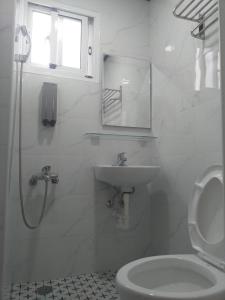 La salle de bains blanche est pourvue d'un lavabo et de toilettes. dans l'établissement Old street little house, à Chaozhou