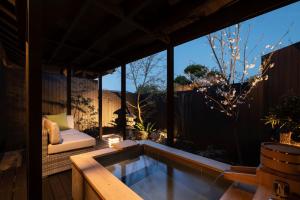 a backyard patio with a swimming pool and a table at Nazuna Obi Onsen Resort in Nichinan