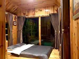 Ce lit se trouve dans un dortoir doté d'une fenêtre. dans l'établissement Đèn lồng homestay & coffee, à Đà Lạt