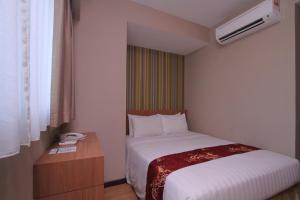 a hotel room with a bed and a nightstand and a bed sidx sidx sidx at Likas Square - KK Apartment Suite in Kota Kinabalu